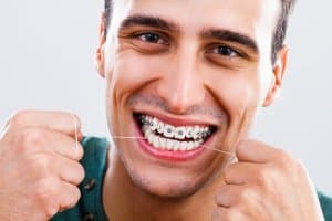 Zahnseide ist essentiell bei einer festsitzenden Zahnspange.