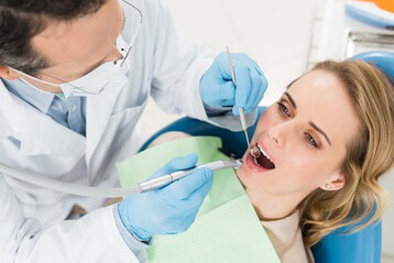 Zahnarzt überprüft Zähne von Patientin