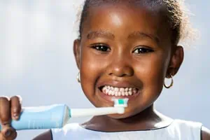 Kleines Mädchen beim Zähneputzen mit elektrischer Zahnbürste