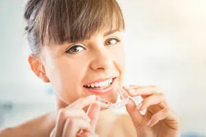 Frau mit gerade Zähnen trägt eine Invisalign Zahnspange