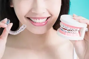 Frau vergleicht Arten von Zahnspangen