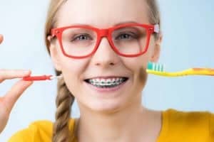 Junge Frau beim Zähneputzen mit Zahnspange