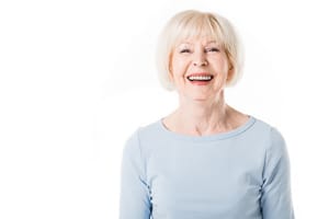 Ältere Frau lächelt mit weißen Zähnen
