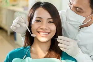 Frau lächelt beim Zahnarzt