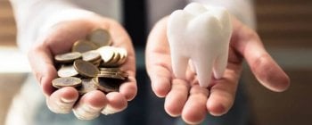 Person Holding White Tooth And Golden Coins