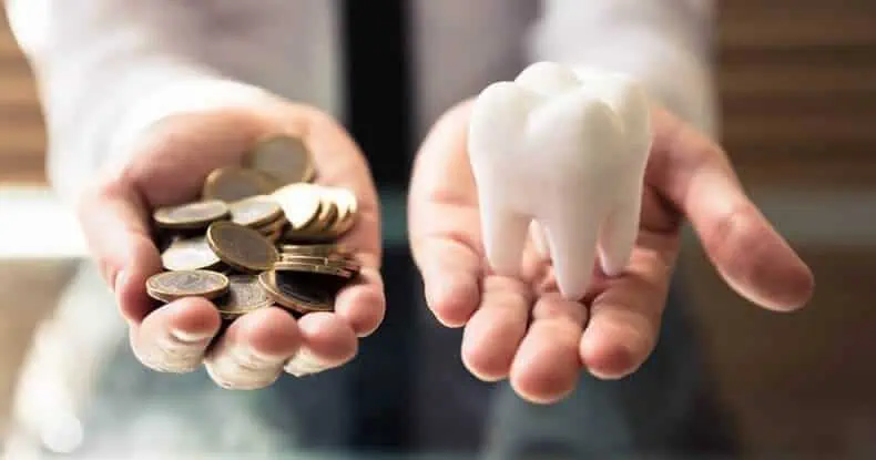 Person Holding White Tooth And Golden Coins