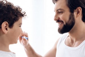 father holding kid's toothbrush