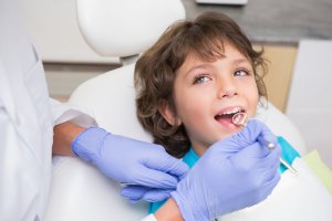 dentist checking boy's teeth