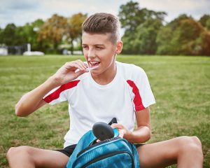 boy using invisalign aligners to straighten teeth