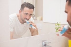 Hombre llevando a cabo su cepillado dental en casa