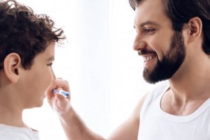 father holding kid's toothbrush