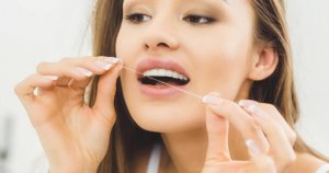 woman cleaning between teeth