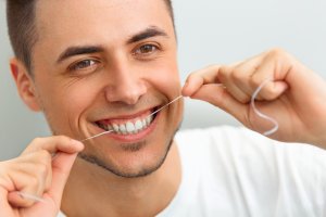 Man flossing teeth