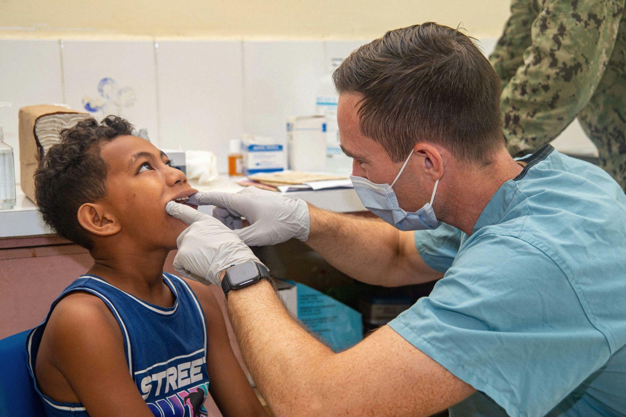 Dentist examining a young boy's teeth during a children's dental check-up