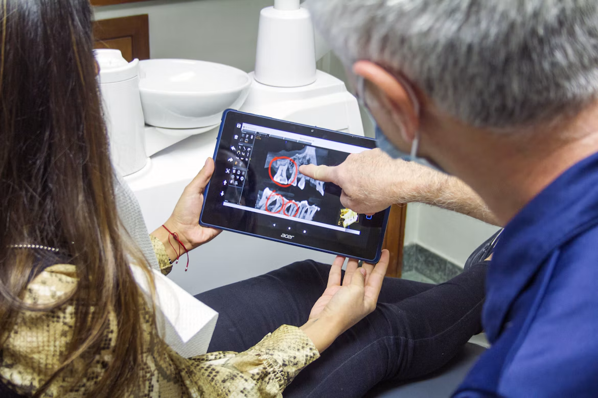 Dentist and patient reviewing a dental scan on a tablet