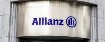 Signage of Allianz, featuring the company name in blue on a metallic background, located on a building facade.